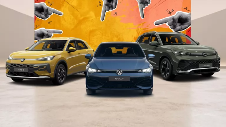 Ein VW T-Roc, VW Golf und VW Tiguan parken nebeneinander vor einer Wand die angemalt worden ist und auf der Zeigefinger zu sehen sind.
