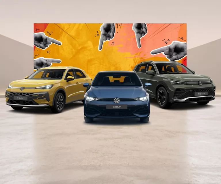 Ein VW T-Roc, VW Golf und VW Tiguan parken nebeneinander vor einer Wand die angemalt worden ist und auf der Zeigefinger zu sehen sind.