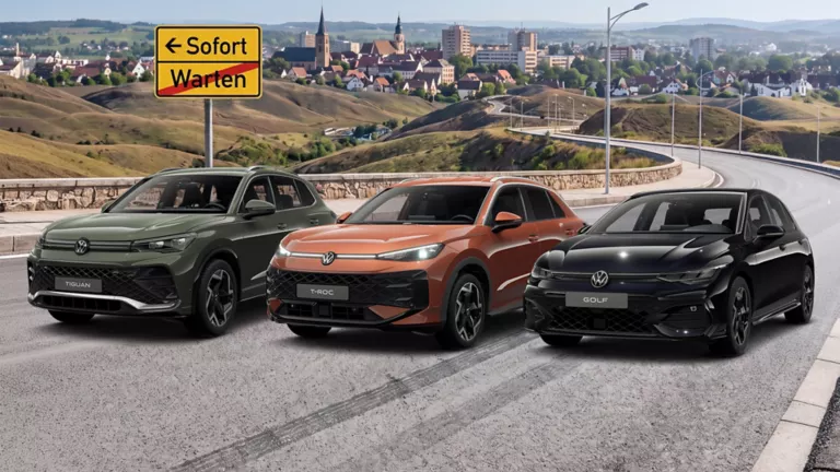 Ein VW Tiguan, VW T-Roc und VW Golf parken an einer Straße. Im Hintergrund sieht man eine Stadt.