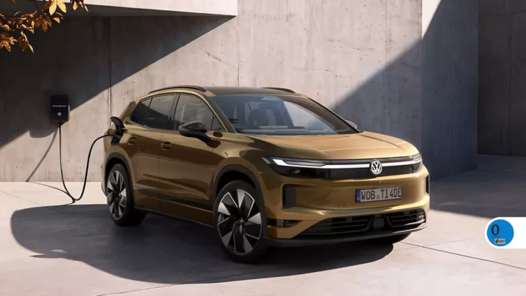 Un Volkswagen ID.Tiguan dorado cargando junto una pared de hormigón