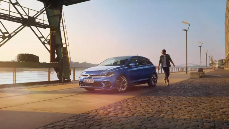 Un chico junto un Volkswagen Polo en el puerto