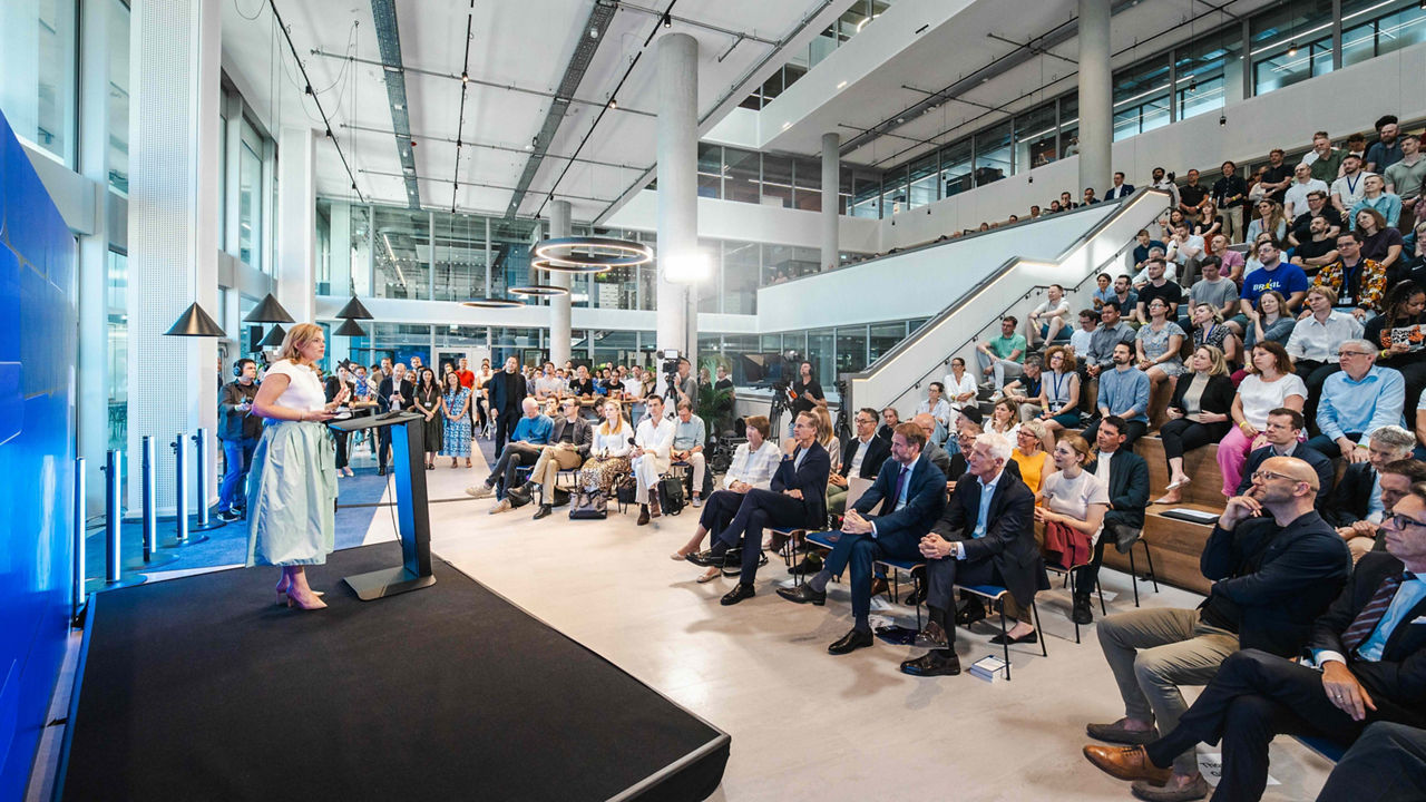 Corporate event at the Automotive Software Campus Berlin featuring a speech from Julia Klöckner with an engaged audience in a modern innovation hub environment.