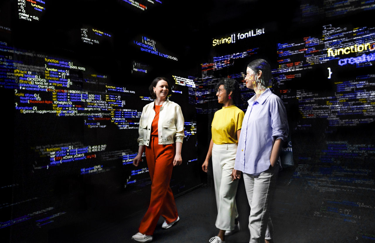 Three individuals walking in front of a background filled with colorful lines of code