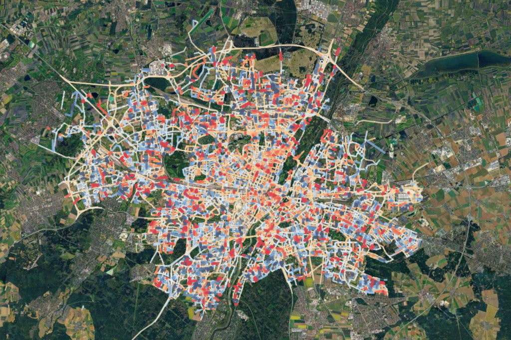 Citywide satellite map of Munich highlighting road temperature data through colored street segments. The visualization illustrates heat islands and temperature differences across urban and suburban districts.