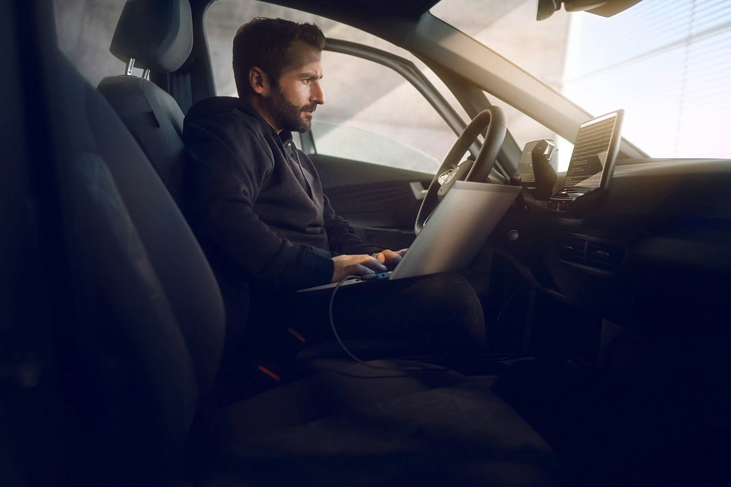man with a laptop inside of a car