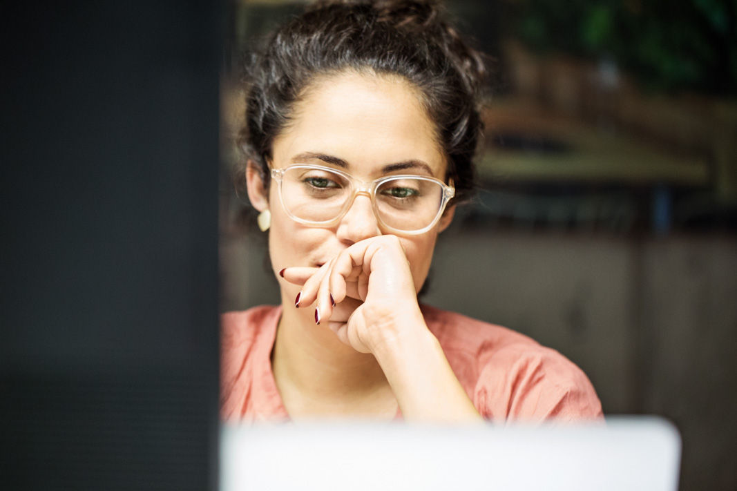 Thoughtful young businesswoman using computer in office