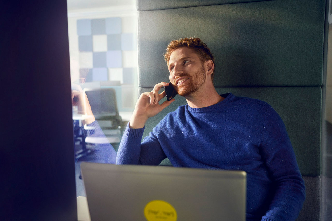 men with blue pullover in phone booth