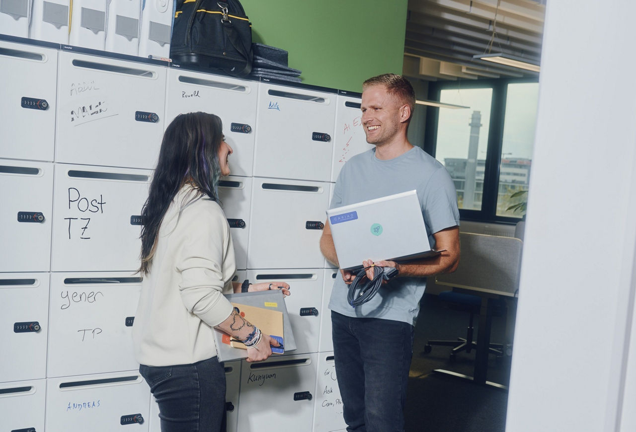 Young professionals talking and organizing documents in a modern office.