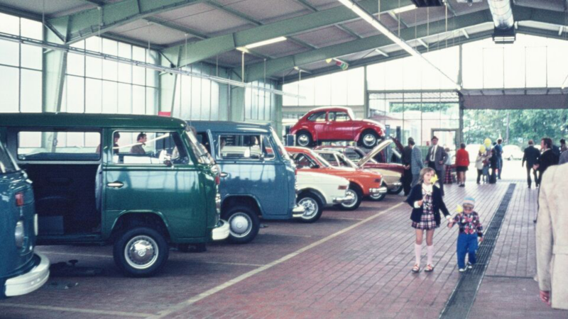 Ausgestellte Volkswagen Modelle in einer Halle mit Besuchern 1971