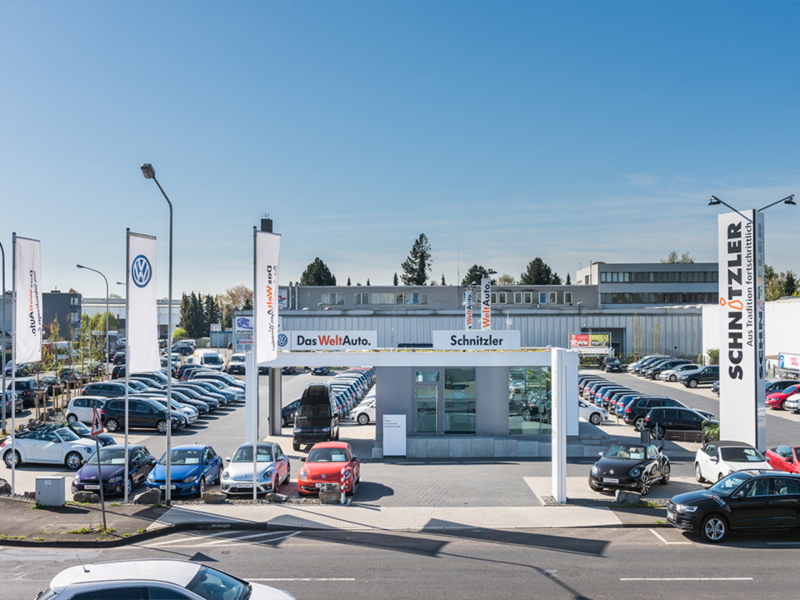 Blick auf den Hof von dem Autohaus Schnitzler mit vielen parkenden VW-Fahrzeugen 