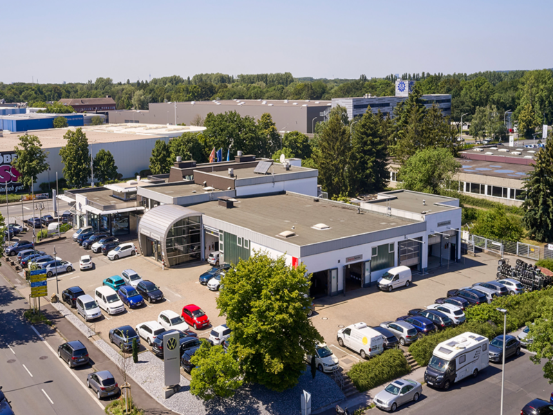 Autohaus Schnitzler aus der Vogelperspektive mit vielen parkenden VW-Fahrzeugen auf dem Hof