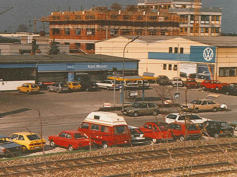 Autohaus Moser von oben, draußen, alte VW-Modelle parkend