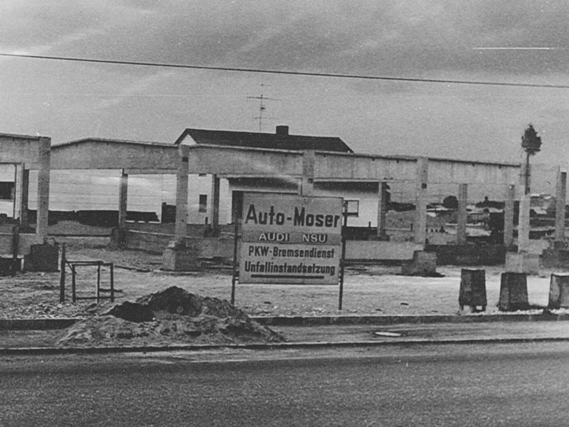 Umbau Autohaus Moser, schwarz-weiß-Aufnahme, Schild mit Schrift "Auto Moser-Pkw Bremsendienst, Unfallinstandsetzung"