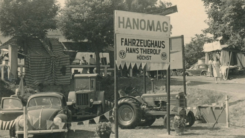Schwarz-Weiß-Fotografie einer Autoausstellung von Thierolf in Höchst mit VW Käfer