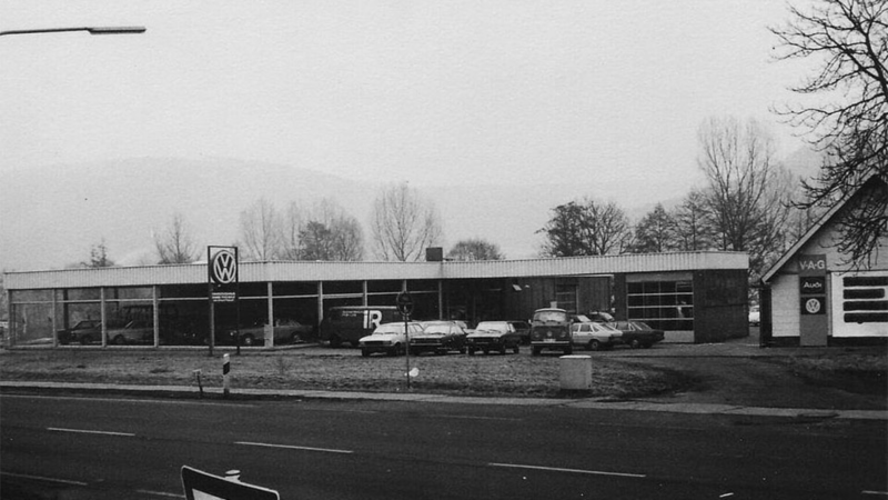 Schwarz-Weiß-Fotografie von Autohaus Thierolf mit parkenden VW Pkw und VW-Logo