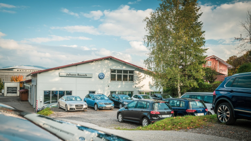Außenaufnahme vom Autohaus Johann Rausch mit parkenden Volkswagen