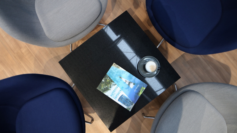Draufsicht eines VW-Prospekts auf einem Tisch umgeben von vier Stühlen