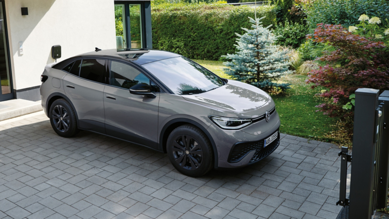 Grauer VW ID.5 steht vor einem modenen Haus, Ansicht schräg von vorne