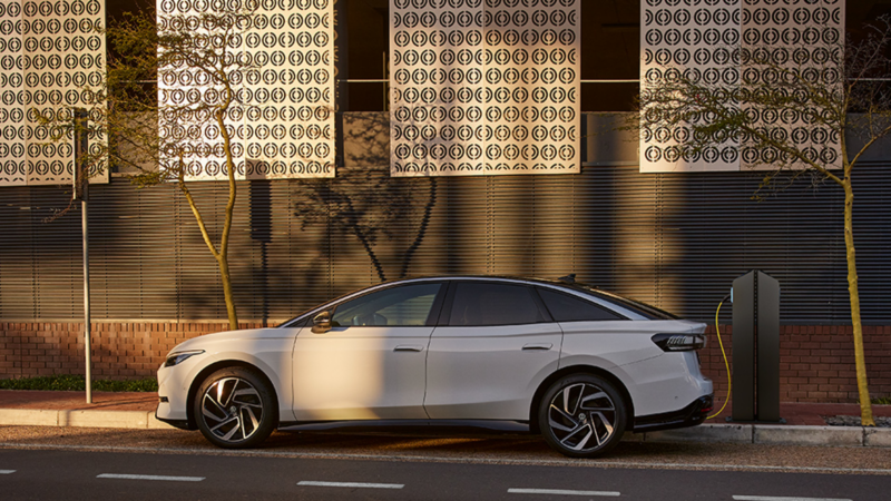 Blick von oben auf den VW ID.7, der auf einem Parkplatz in der Sonne steht.