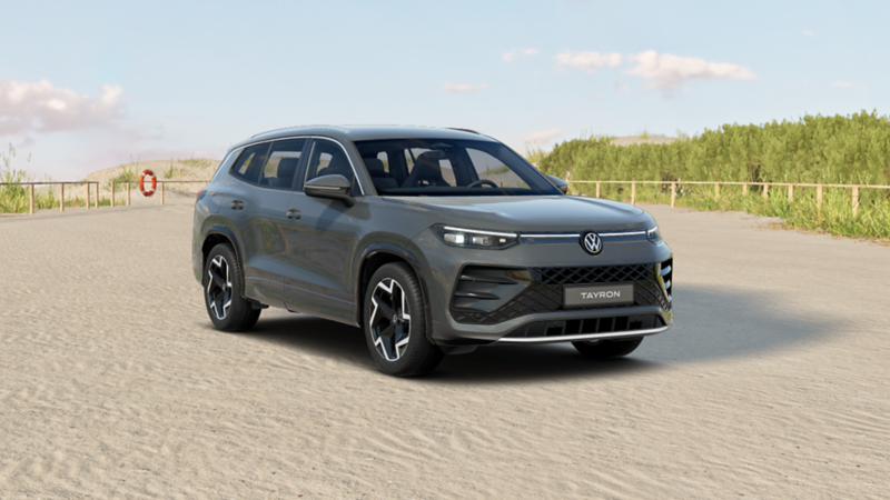 Uranograuer VW Tayron R-Line geparkt am Meer mit Rettungsring und Parkplatzschild im Hintergrund