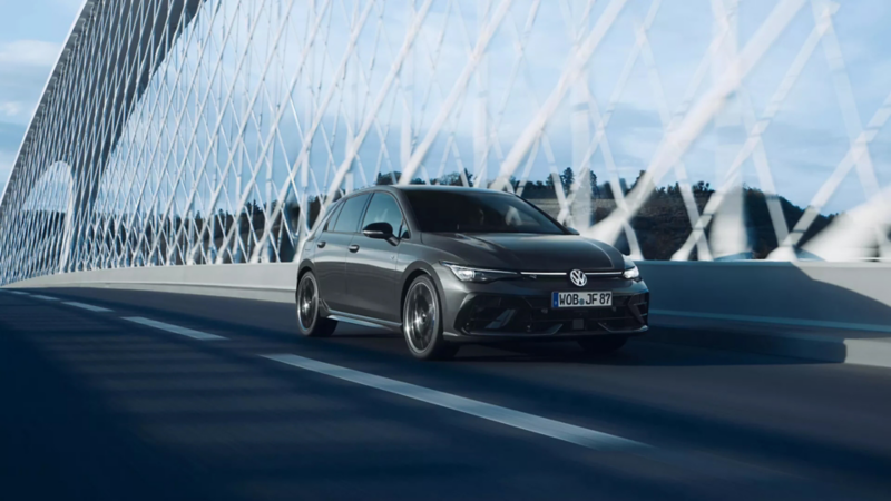 VW Golf R in Delfingrau Metallic fährt Straße entlang, im Hintergrund malerische Altstadt