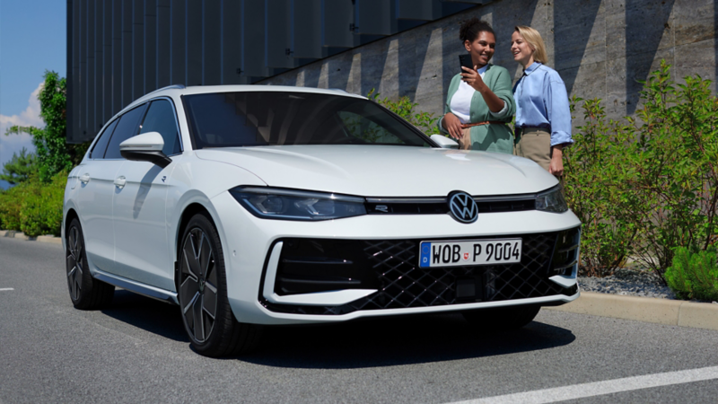 Ein weißer Volkswagen Passat der auf einem Parkplatz vor einem modernen Gebäude steht.