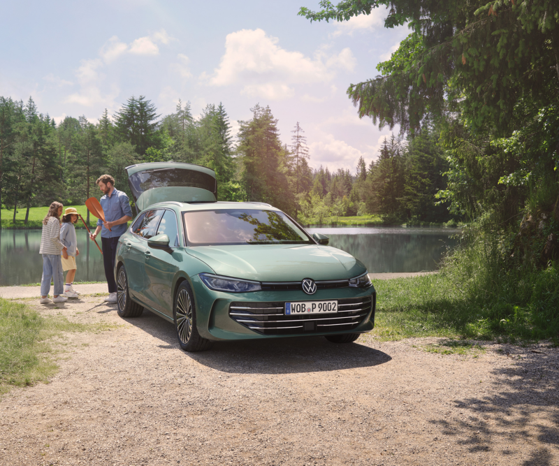 Ein Passat in einem zarten grünmetallic der an einem See steht, die Heckklappe ist geöffnet - der Badetag kann starten.