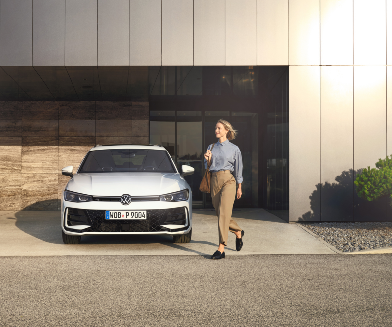 Ein weißer Passat der in einer großzügigen Garage eines modernen Gebäudes  steht.