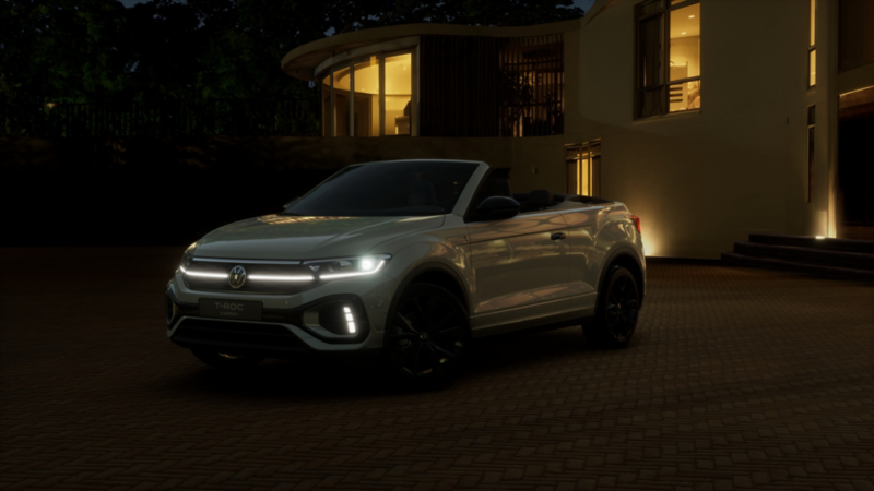 Volkswagen T-Roc Cabriolet Edition Karmann in Silber bei Nacht vor modernem Haus mit beleuchteten Fenstern