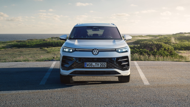 Ein weißer VW Tayron parkt, Blick auf gestaltete Front mit IQ.LIGHT-Scheinwerfern