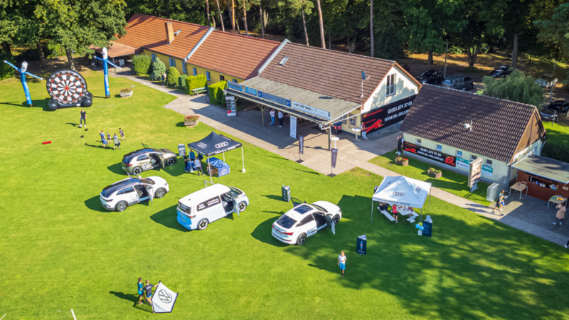 VW Fahrzeuge im Fußballfeld mit Familen