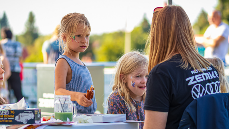 Zwei Kinder, die sich mit Farben schminken lassen