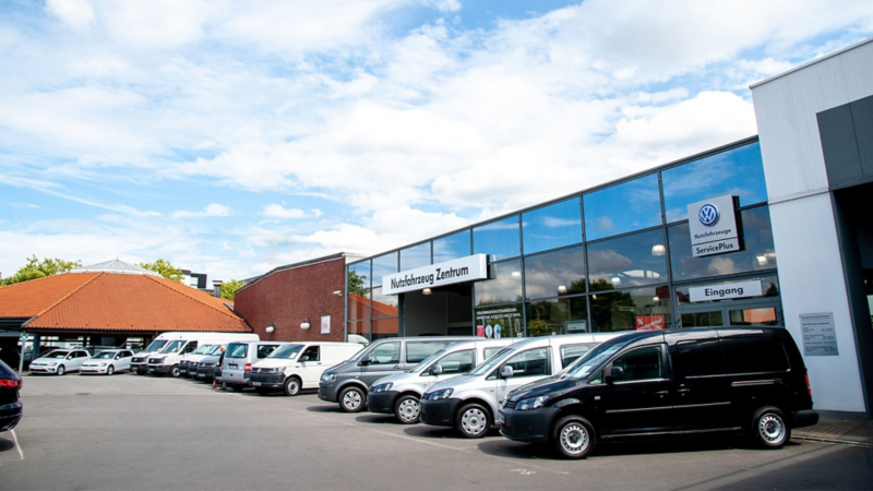 Autohausbild Nutzfahrzeug Zentrum von außen, parkende VW-Nutzfahrzeuge davor