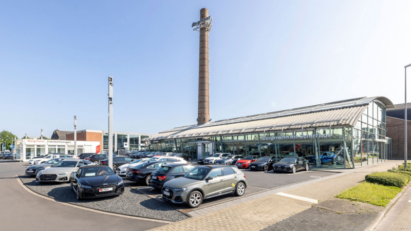 Parkplatz vor dem Autohaus Eingang mit parkenden Autos