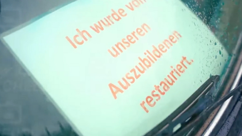 Schild in der Frontscheibe eines Oldtimers: "Ich wurde von unseren Auszubildenen restauriert".