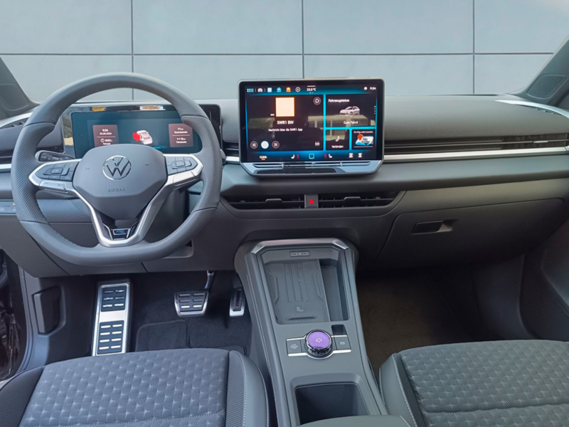 Blick vom Fahrer auf das Armaturenbrett eines schwarzen  T-Roc R Line. 