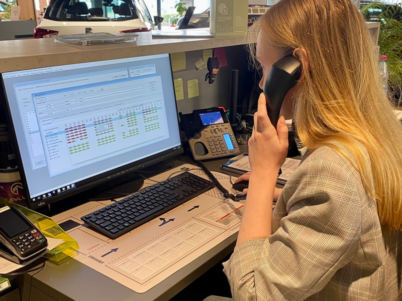 Alina sitzt vor Computer und telefoniert