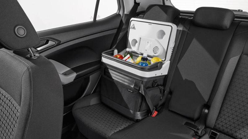 Otwarta lodówka samochodowa z napojami i jedzeniem, zabezpieczona pasem bezpieczeństwa na tylnym siedzeniu Volkswagena T-Cross