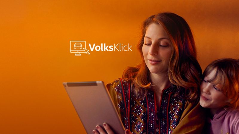 A woman and a child browsing on a tablet at home, outgoing link to VolksKlick page