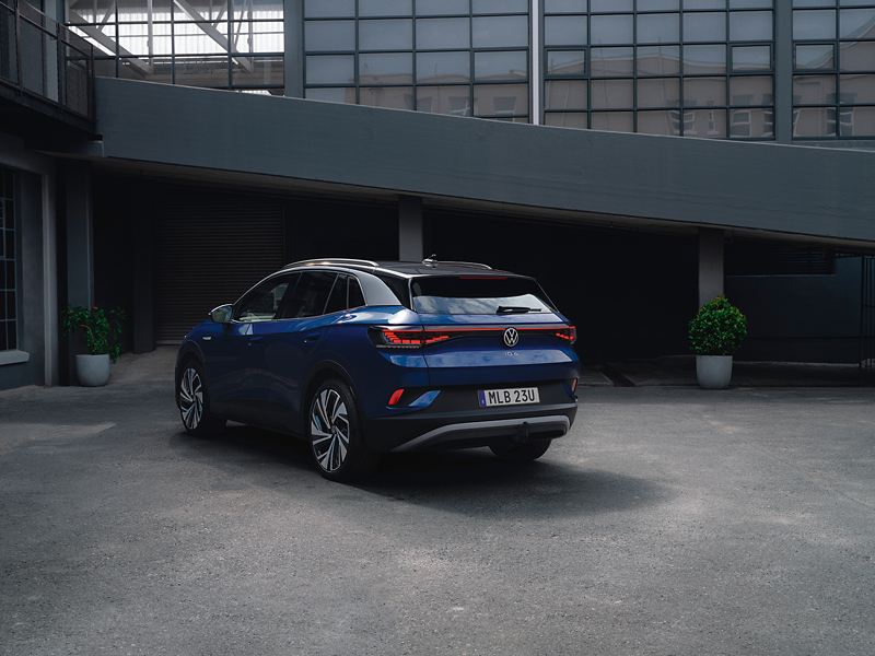 Blå Volkswagen ID.4 parkerad framför en byggnad.
