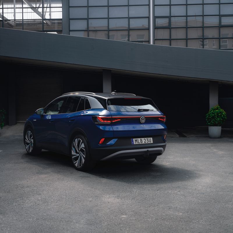 Blå Volkswagen ID.4 parkerad framför en byggnad.