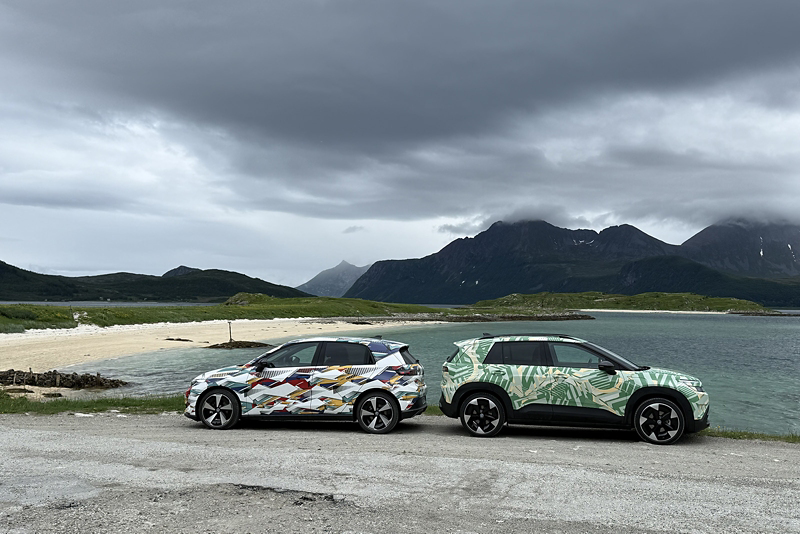 ID. Cross och ID. Polo står med bakluckorna mot varandra framför en strand