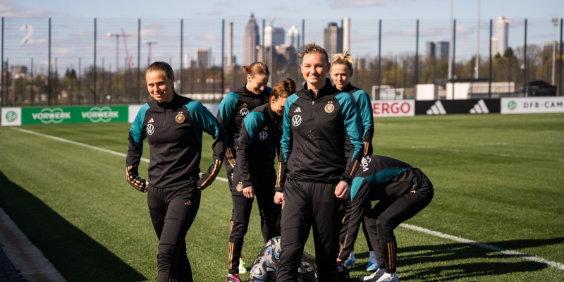 DFB Frauen packen Fußbälle auf dem Rasen aus.