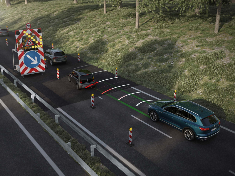 Cars driving past road works 