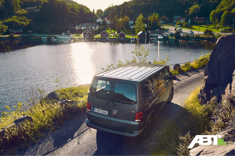 Une Volkswagen Caravelle sur une route en bord de mer.