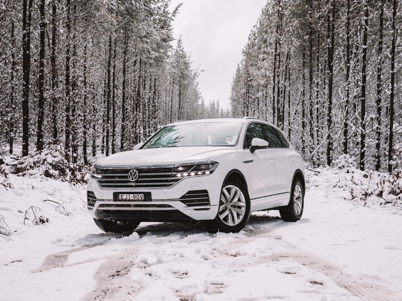 White VW surrounded by snowy woods