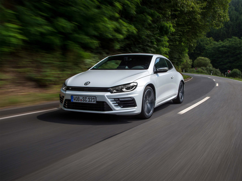 Front view of white VW car driving on road