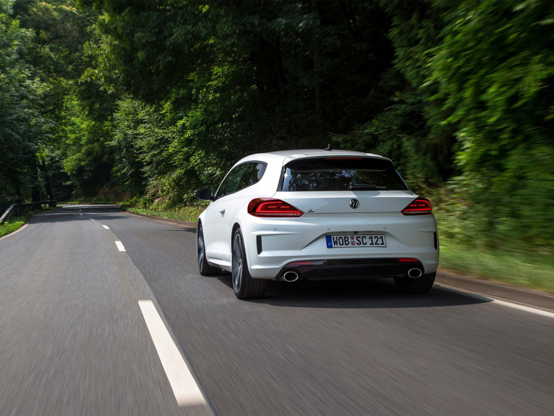 Rear view of white VW driving on road