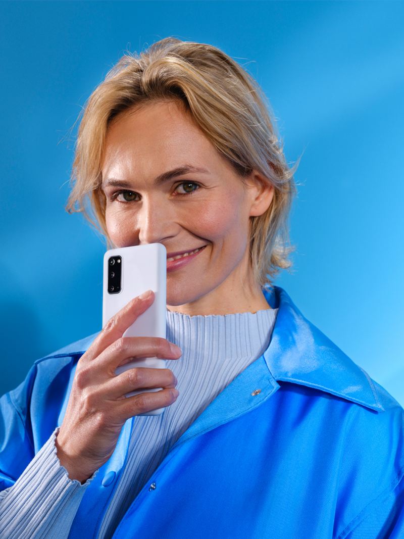 Kobieta ze smartfonem na niebieskim tle