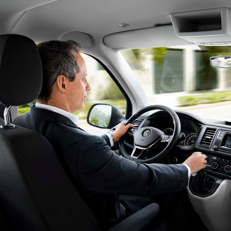 Un hombre en el interior de un vehículo VW, conduciendo.